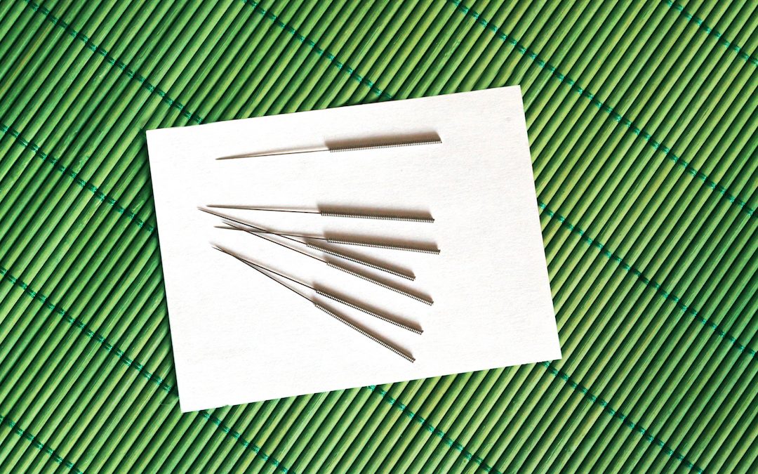 acupuncture needles on a white substrate and a bamboo napkin